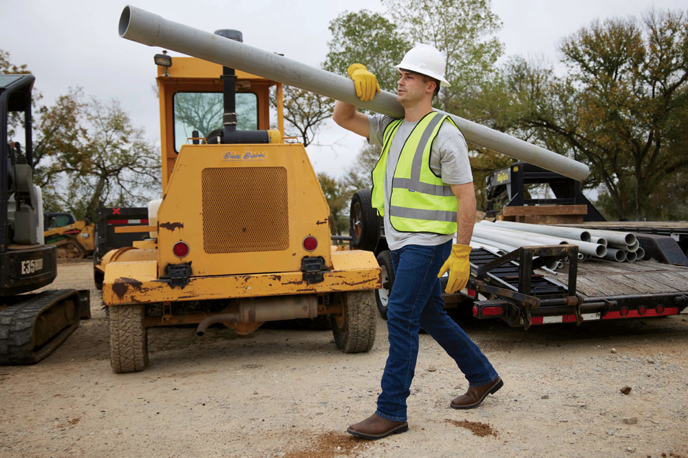 A construction worker wearing Justin Work boots on a job site
